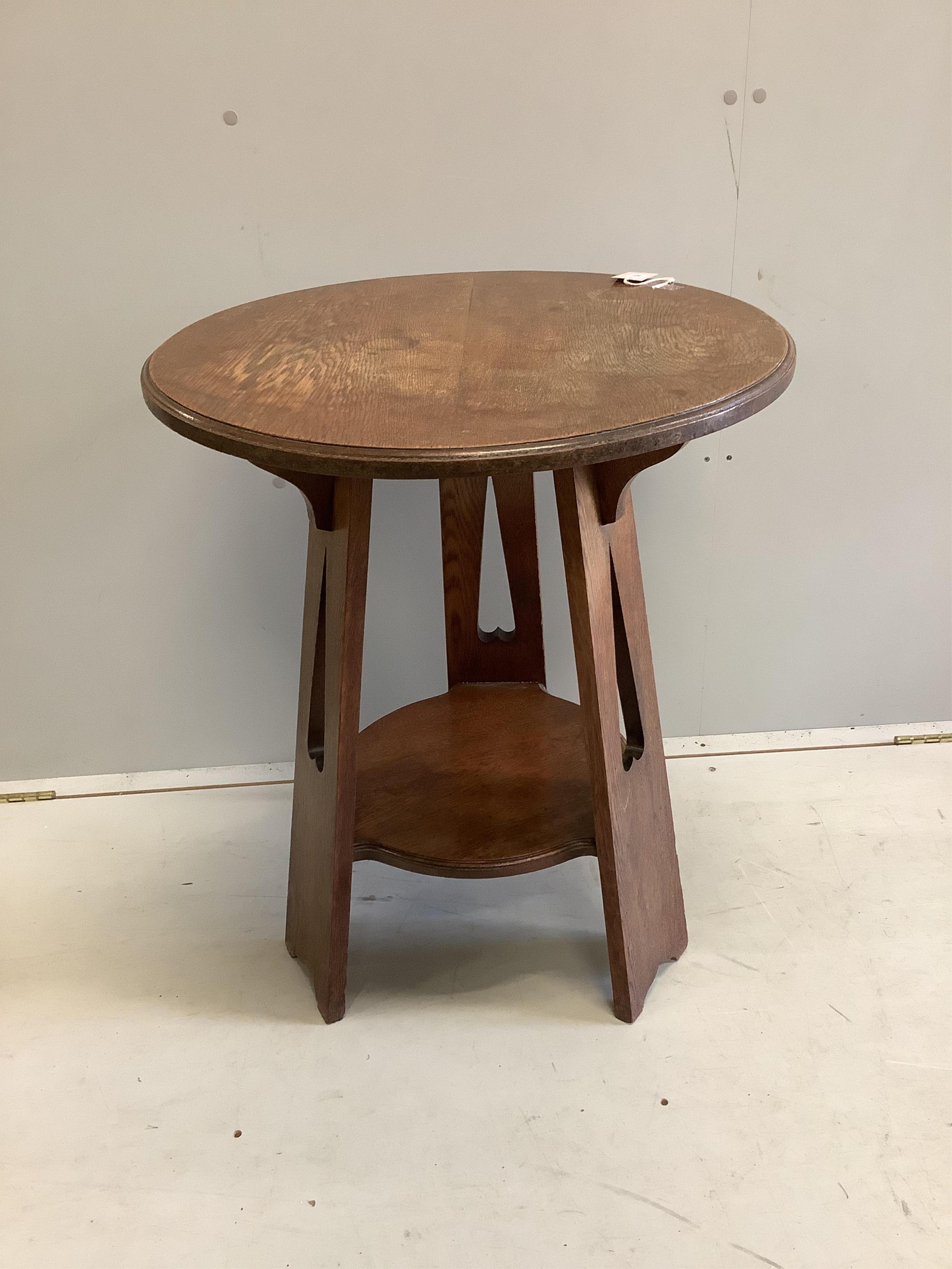 An early 20th century Liberty style circular oak occasional table, diameter 60cm, height 72cm. Condition - fair, top water stained together with a two tier smokers stand.